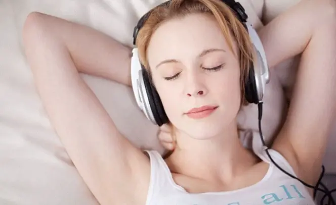 Mujer durmiendo con audífonos.