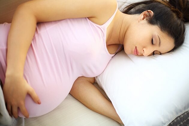 Mujer embarazada acostada de lado
