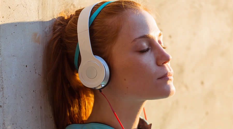 Mujer joven escuchando música con audífonos